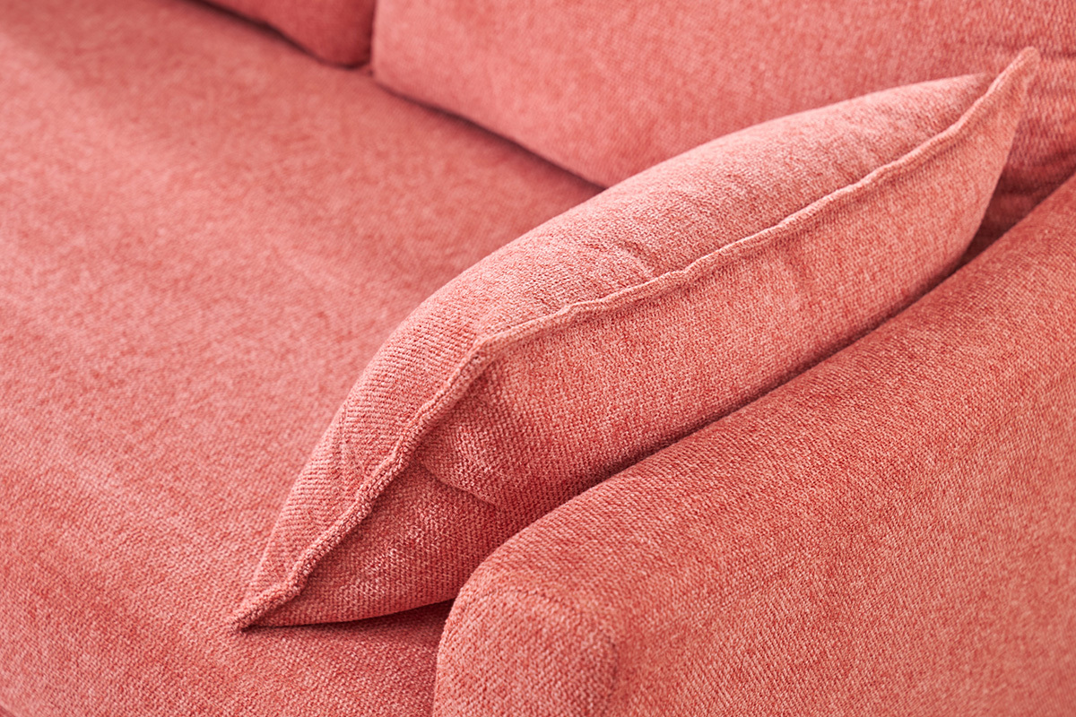 Primer plano del reposabrazos y coj�n de un sof� de tela efecto terciopelo terracota.