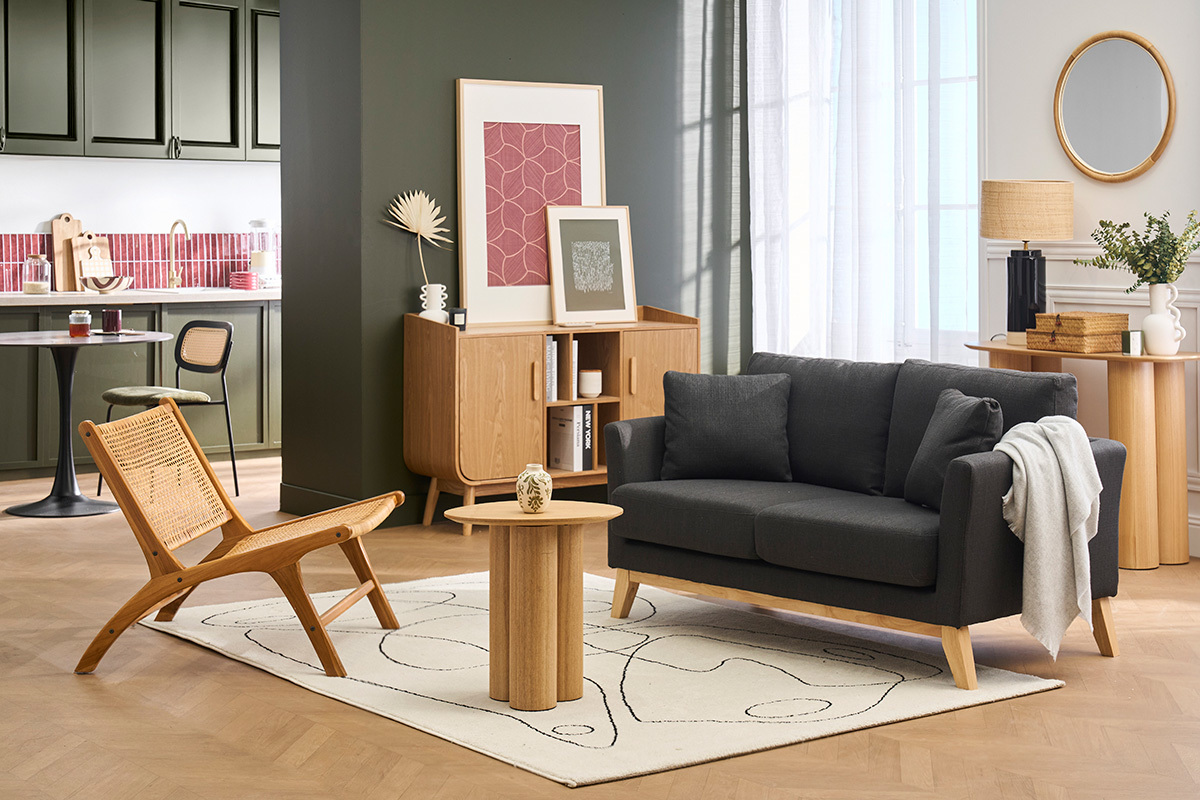 Sof� de 2 plazas OSLO en gris oscuro sobre alfombra, con mesa baja y silla de madera, vista de frente.