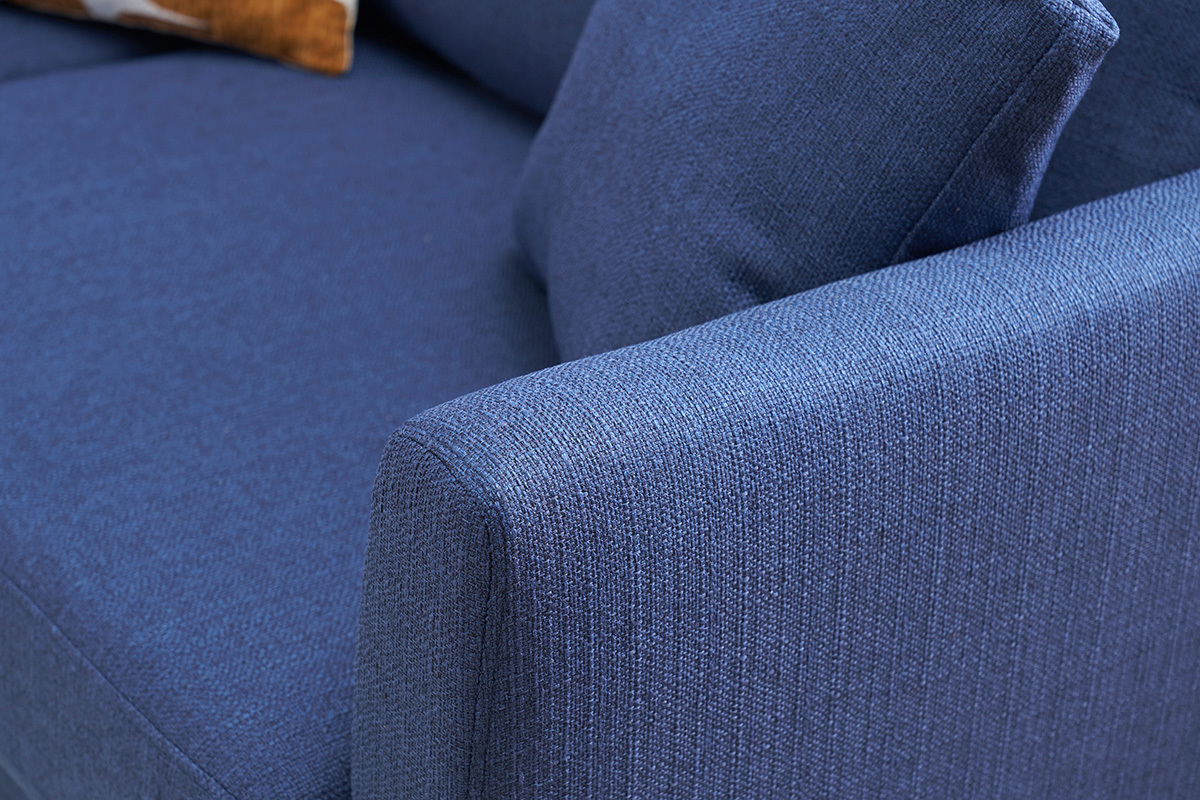 Primer plano del reposabrazos del sof� escandinavo de tela azul oscuro.
