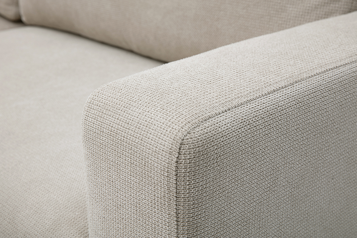 Zoom sobre el reposabrazos y el asiento del sof� esquinero convertible NESTO en tejido chenilla beige.
