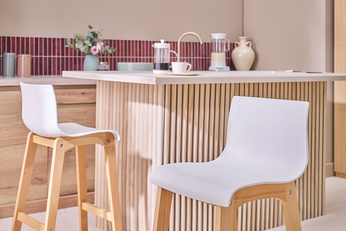 Taburetes de bar dise�o madera y blanco H65 cm frente a una isla central.