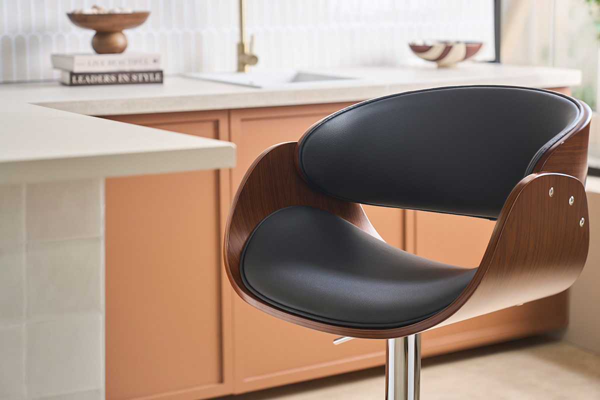 Taburete de bar de dise�o negro y madera oscura, vista de cerca del asiento y el respaldo