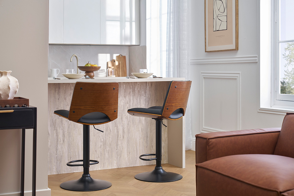 Dos taburetes de bar PANACH de madera oscura y negra, frente a una isla de cocina.
