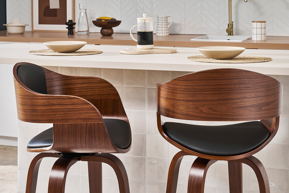 Dos taburetes de bar de madera oscura y negra, dise�o, colocados frente a un mostrador de cocina.