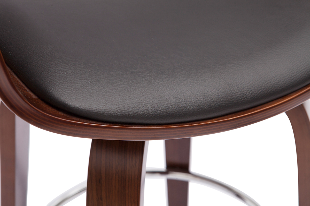 Detalle de un taburete de bar con asiento negro de poliuretano y estructura de madera te�ida de nogal, reposapi�s cromado.