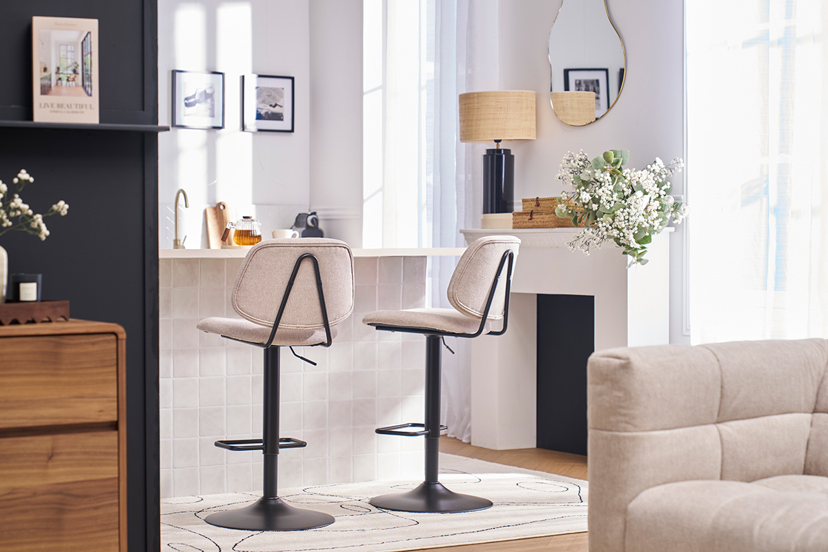 Dos taburetes de bar con asiento de tela beige y pie de metal negro, colocados frente a una isla de cocina.