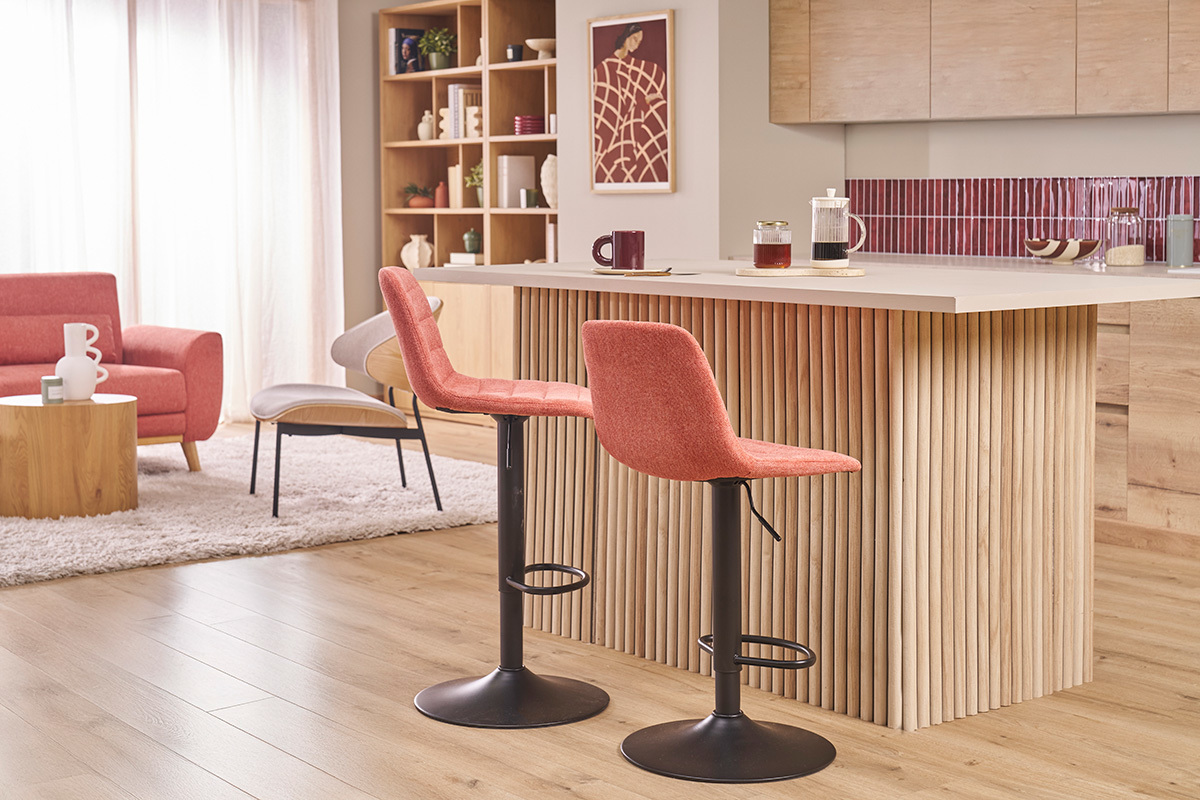 Taburetes de bar terracota cerca de una isla de cocina de madera.