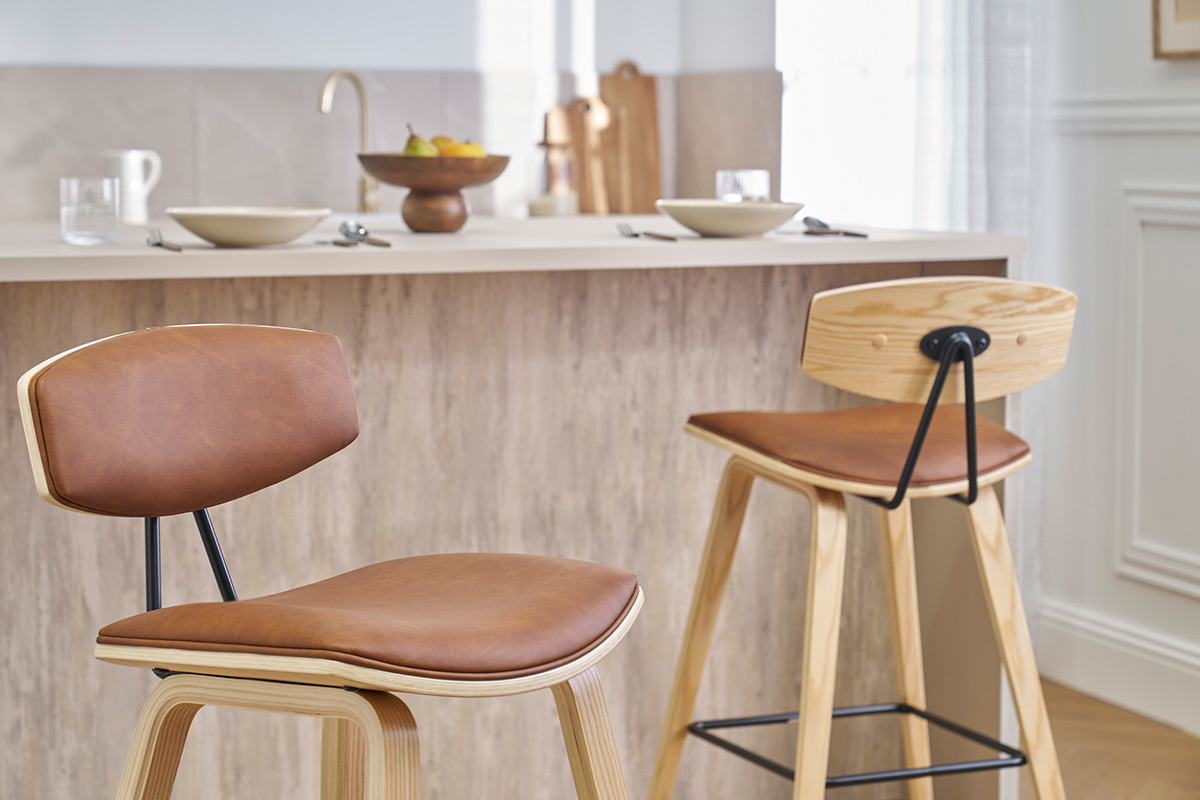 Dos taburetes de bar de diseo marrn y madera clara frente a una encimera de cocina.