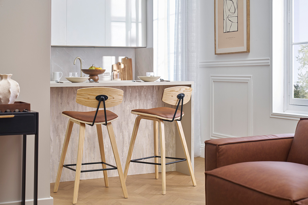 Dos taburetes de bar marrn y madera clara frente a un mostrador en una cocina moderna.