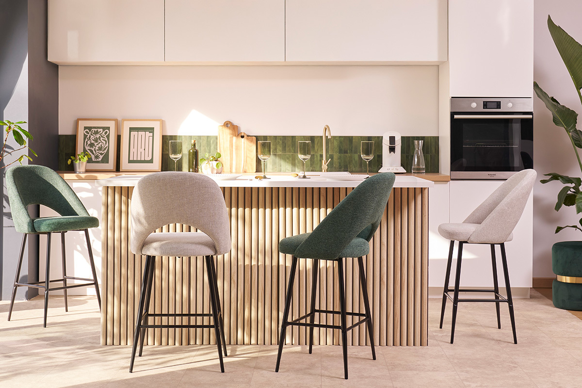 Taburetes de bar coloridos alrededor de una isla de cocina.