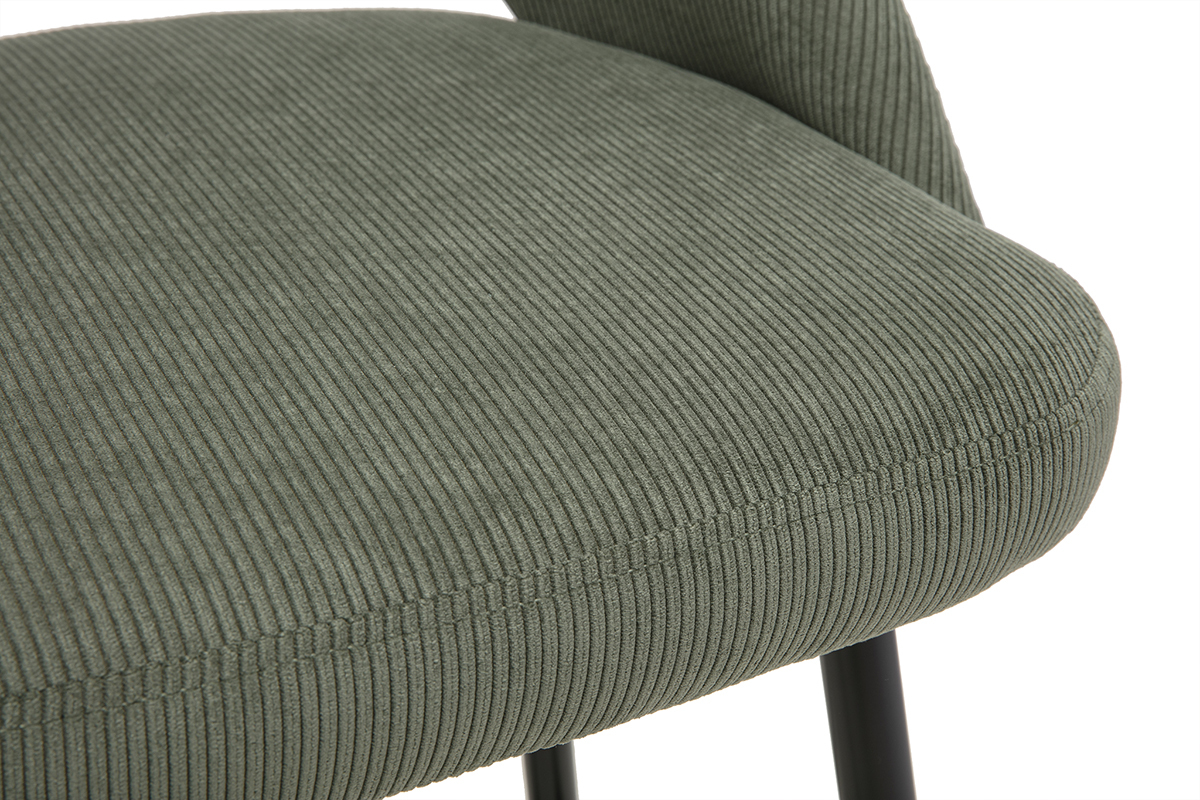 Taburete de bar de pana verde caqui, vista cercana, asiento y patas negras visibles.