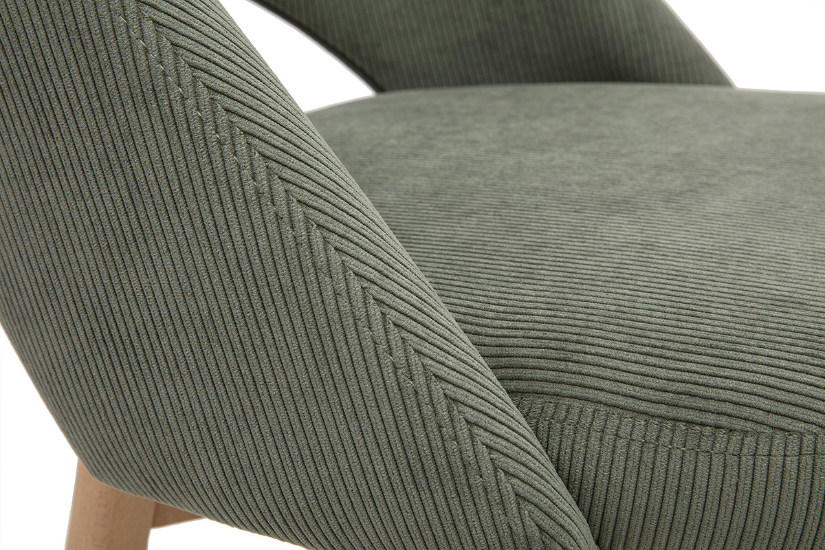 Primer plano de un taburete de tela de terciopelo acanalado verde caqui y madera de caucho.