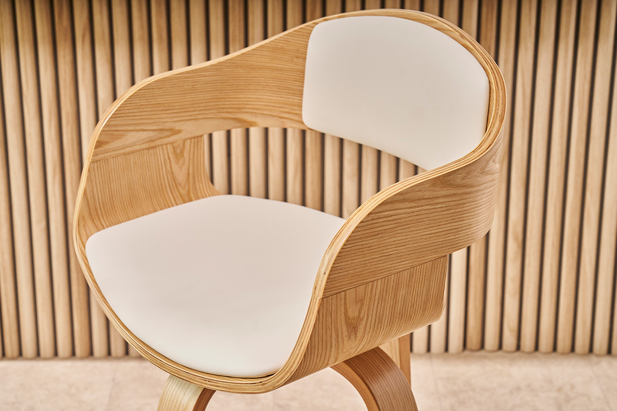 Taburete de bar escandinavo de madera clara con asiento blanco en primer plano.