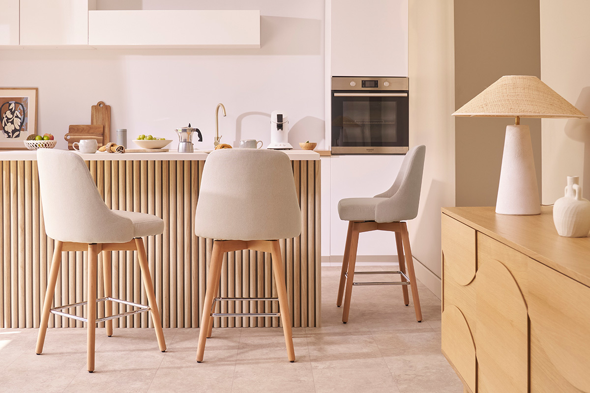 Taburetes de bar escandinavos giratorios de tela beige, en una cocina moderna.