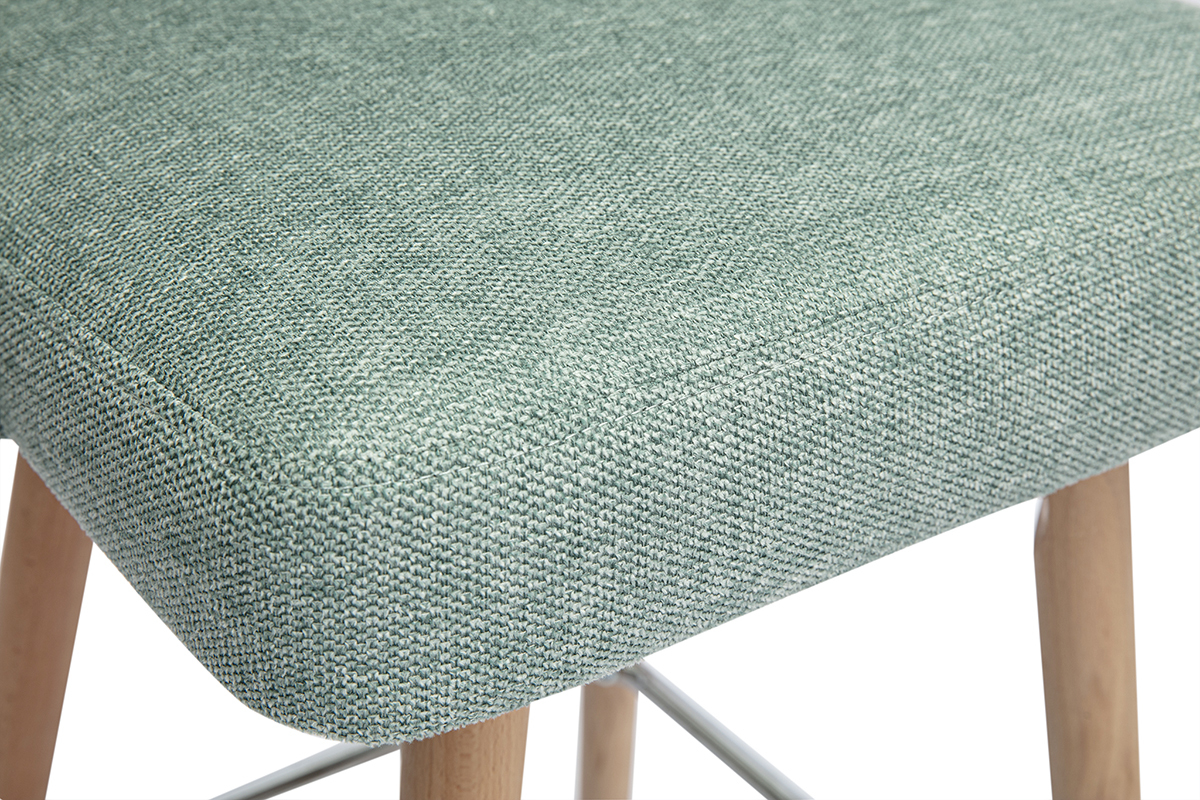 Asiento de tela verde celad�n texturizado del taburete sobre patas de madera.