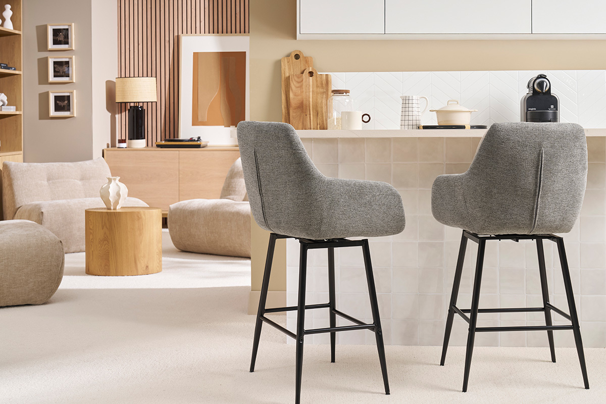 Dos taburetes de bar grises frente a un mostrador en un saln moderno.