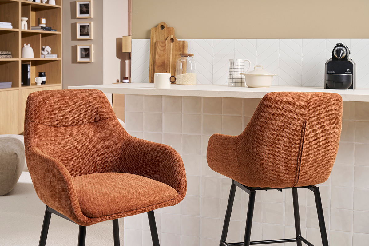 Taburetes ALESS de tela color tierra quemada y metal, cerca de una barra, vista lateral.
