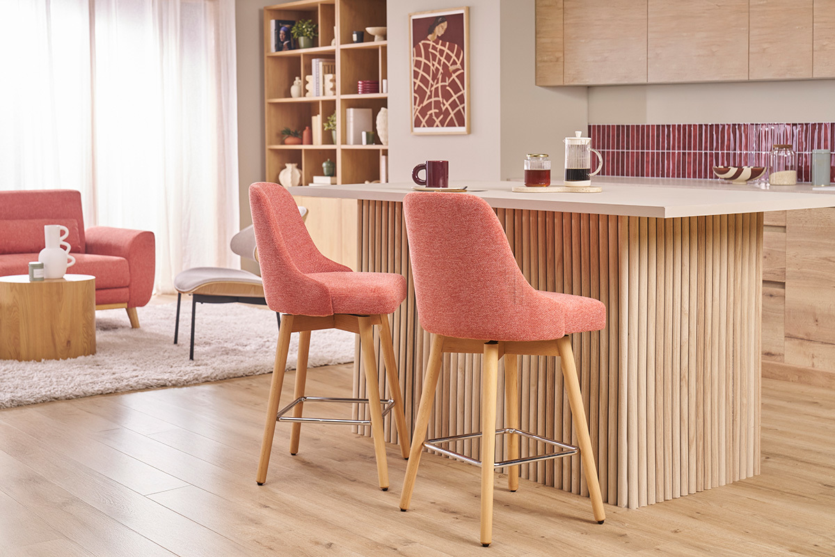 Taburetes de bar escandinavos terracota y madera de haya alrededor de una isla central, vista lateral.
