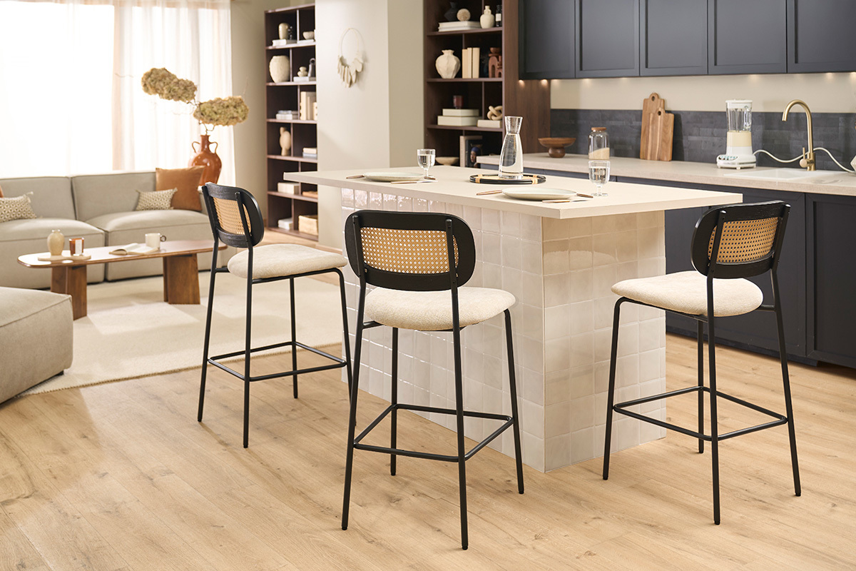 Taburetes de dise�o MIRANDA en tejido de terciopelo beige y metal negro en la barra de una cocina moderna.