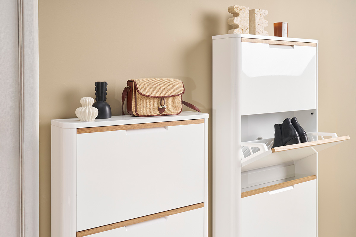 Mueble para zapatos blanco lacado 4 puertas, compartimento abierto con zapatos, objetos decorativos encima.