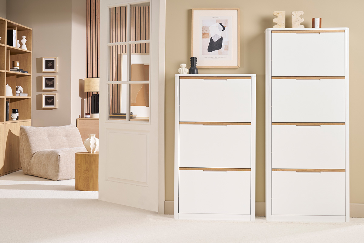 Dos muebles para zapatos blancos KIRK con puertas abatibles en un interior moderno.